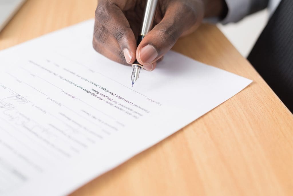 A man signed a document with a calligraphy pen.